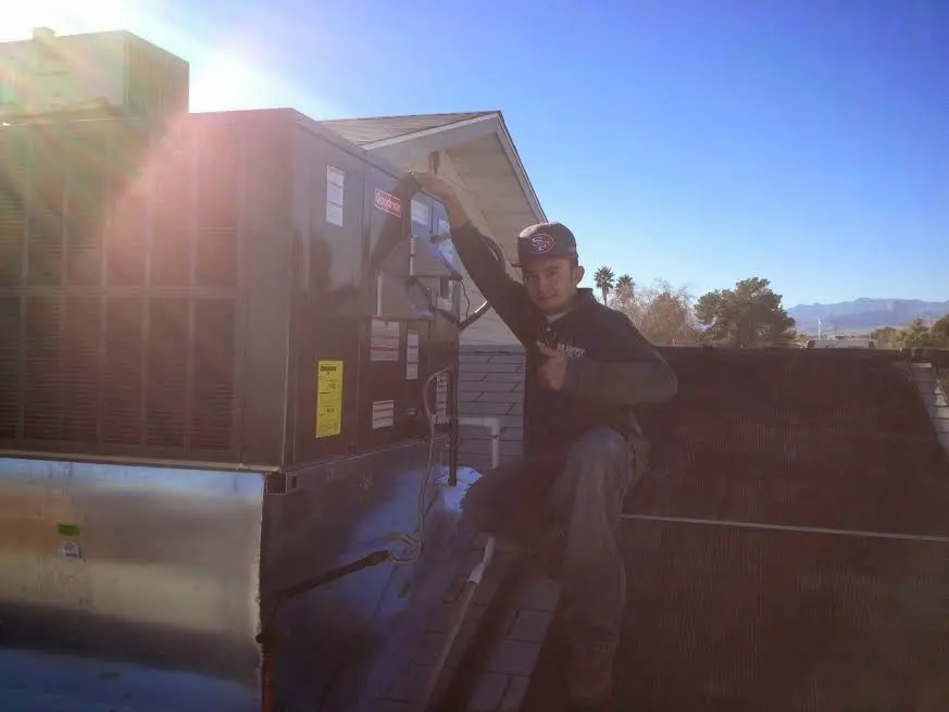 HVAC technician performing Air Duct Cleaning on a rooftop unit in Clarksville